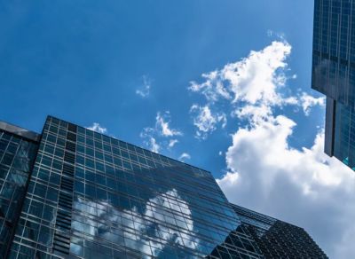 A view of tall buildings with clouds in sky on a sunny day, representing VMware cloud solutions | DXC Technology